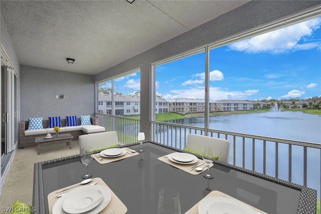 sunroom featuring a water view