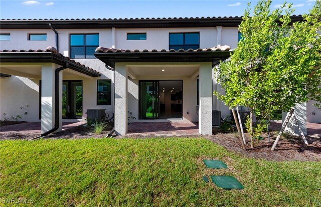 rear view of house featuring central AC, a yard, and a patio