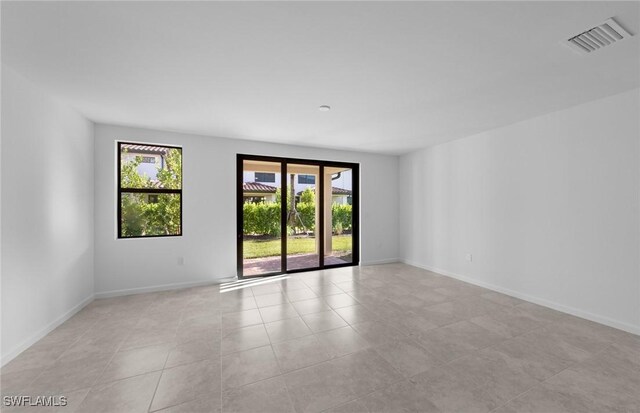 tiled empty room with a healthy amount of sunlight