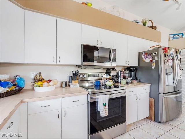 kitchen with white cabinets, appliances with stainless steel finishes, and light tile patterned floors