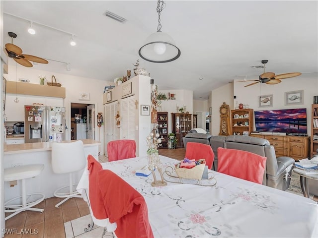 dining room with ceiling fan and light hardwood / wood-style flooring