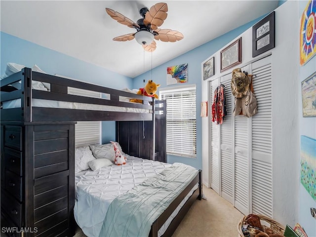 carpeted bedroom with ceiling fan and vaulted ceiling