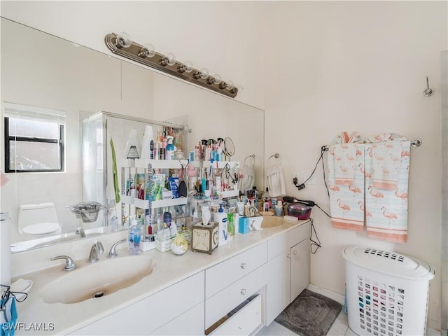 bathroom featuring tile patterned floors, vanity, a shower with shower door, and toilet