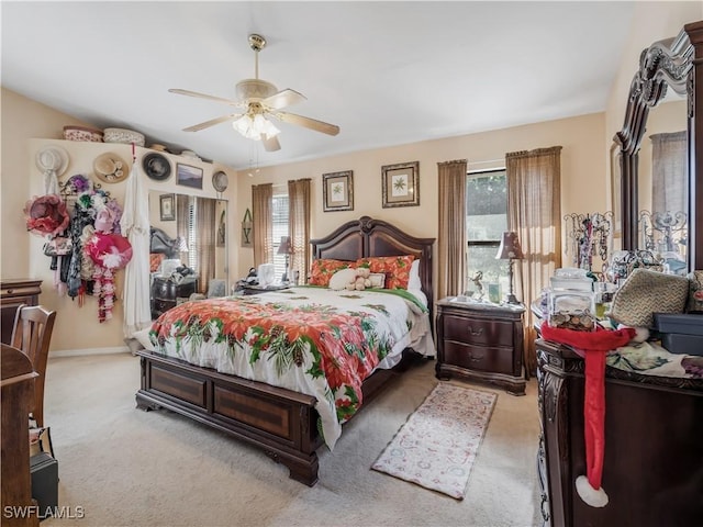 bedroom with ceiling fan, light carpet, and multiple windows