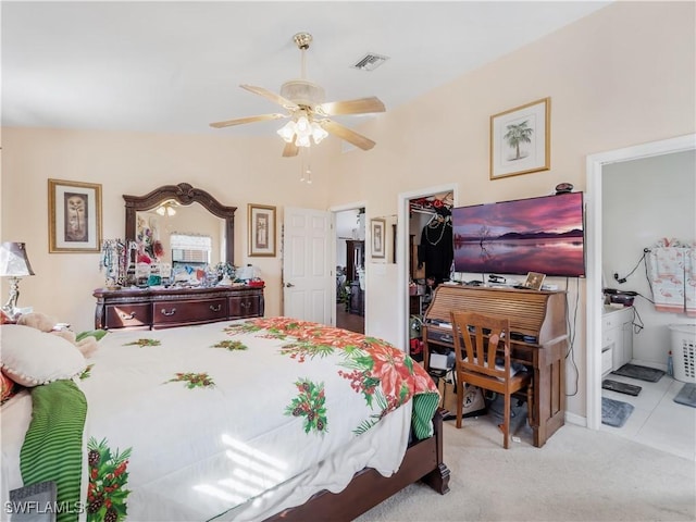 bedroom featuring light carpet, ensuite bath, ceiling fan, a spacious closet, and a closet