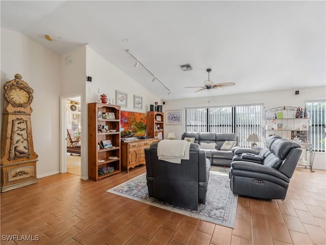 living room with ceiling fan, rail lighting, and vaulted ceiling