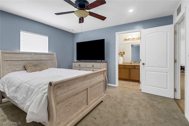 carpeted bedroom featuring sink, ensuite bath, and ceiling fan