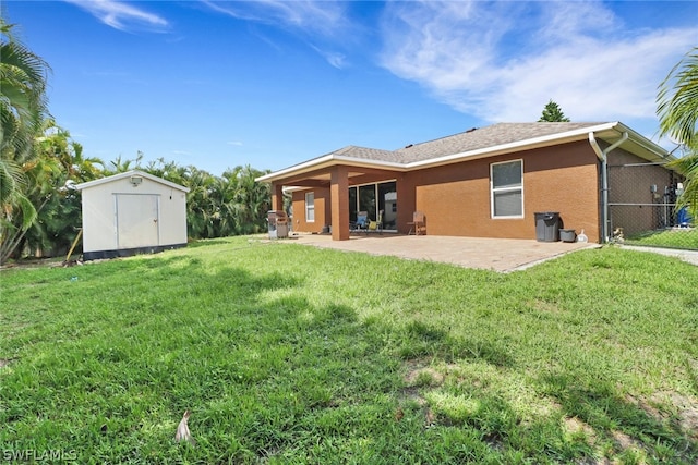 rear view of house featuring a patio, a storage unit, and a lawn