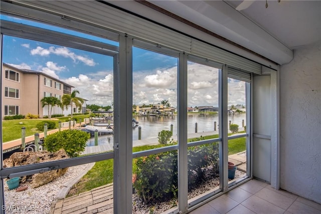 entryway featuring light tile patterned floors and a water view