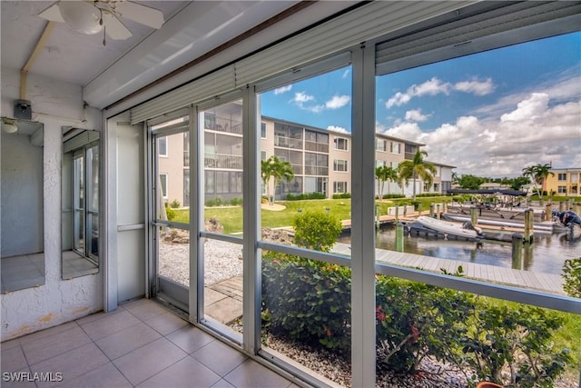 unfurnished sunroom featuring a water view and ceiling fan