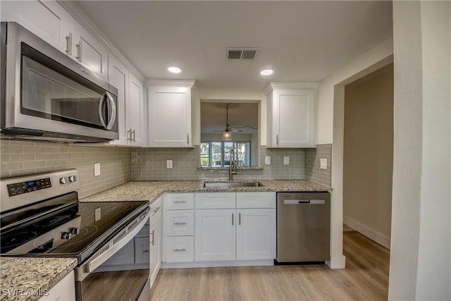 kitchen with white cabinetry, sink, stainless steel appliances, and light wood-type flooring