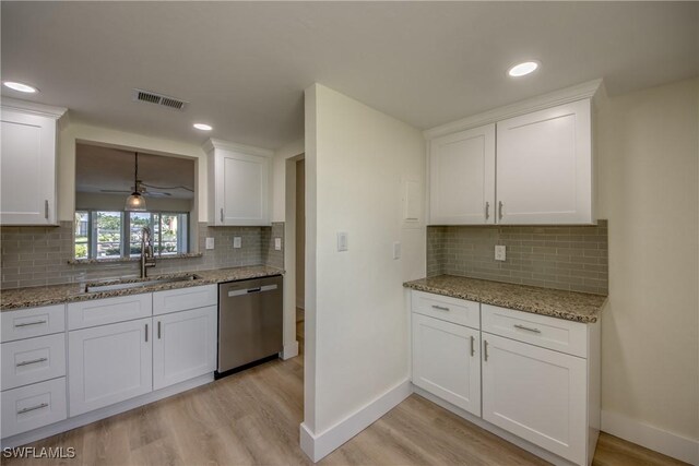 kitchen with light hardwood / wood-style flooring, white cabinetry, dishwasher, backsplash, and sink