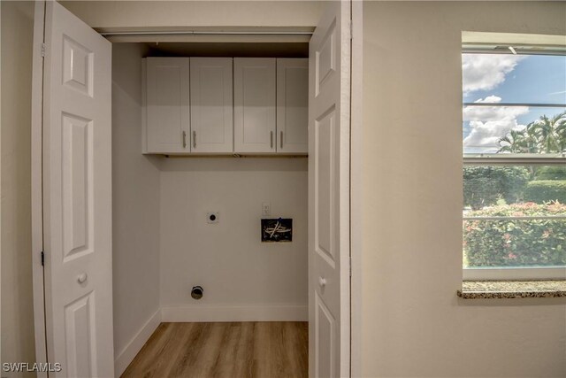 laundry room featuring light hardwood / wood-style flooring, cabinets, and electric dryer hookup