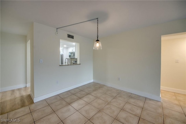 unfurnished dining area featuring sink and light tile patterned floors