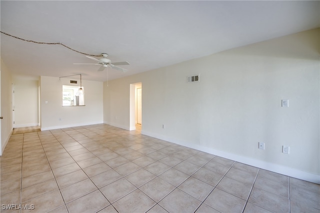 tiled spare room featuring ceiling fan