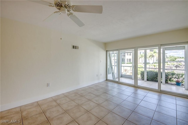 empty room with light tile patterned floors and ceiling fan