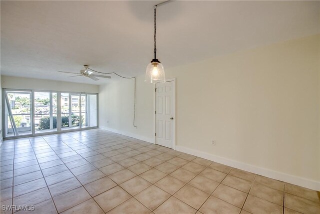 spare room with ceiling fan and light tile patterned floors