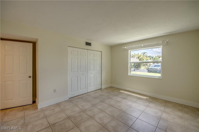 unfurnished bedroom featuring a closet and light tile patterned floors