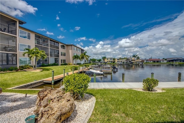 view of dock with a water view and a lawn