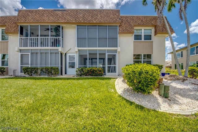 back of house featuring ceiling fan and a yard