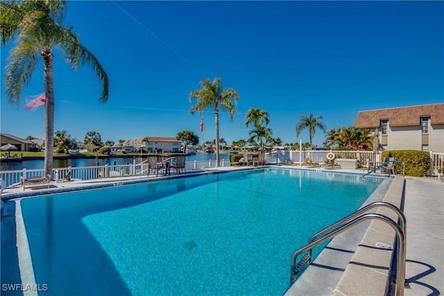 view of swimming pool with a water view and a patio area