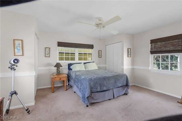 carpeted bedroom featuring a closet, multiple windows, and ceiling fan