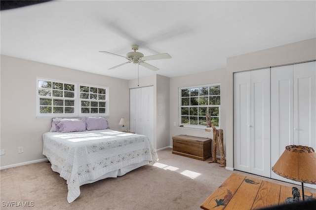 15700 Bahama Way, Bokeelia, FL 33922 - bedroom featuring multiple closets, light carpet, baseboards, and a ceiling fan