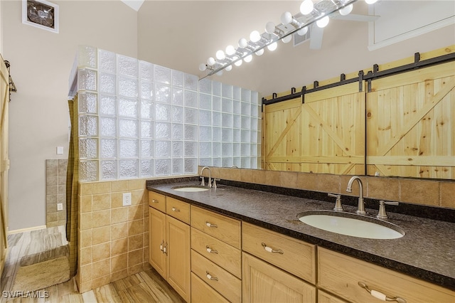 bathroom featuring wood-type flooring, vanity, and tile walls