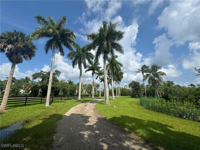 view of property's community with a rural view and a yard