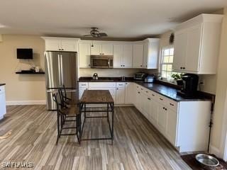 kitchen with ceiling fan, light hardwood / wood-style flooring, white cabinets, and appliances with stainless steel finishes