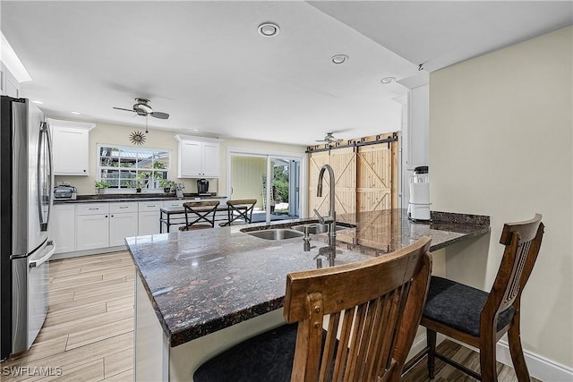 15700 Bahama Way, Bokeelia, FL 33922 - kitchen featuring freestanding refrigerator, a sink, a peninsula, a barn door, and a breakfast bar