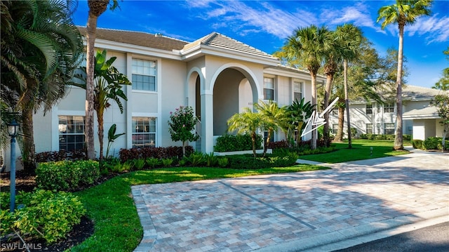 mediterranean / spanish house featuring a front lawn