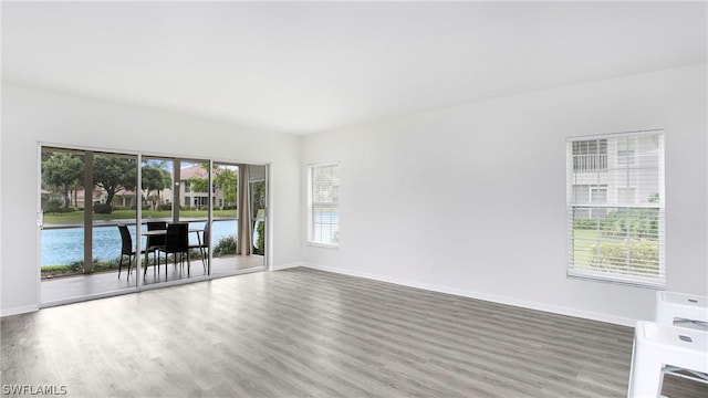 empty room featuring a water view and wood-type flooring