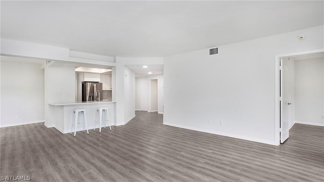 unfurnished living room with dark hardwood / wood-style flooring