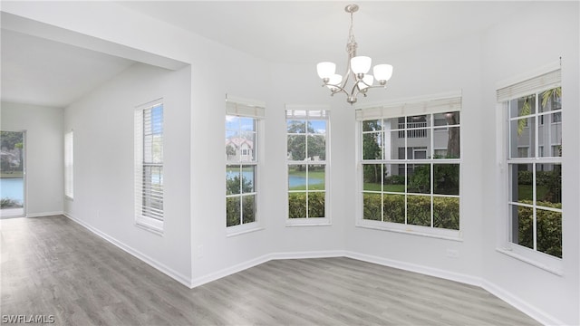 unfurnished sunroom featuring a healthy amount of sunlight and a notable chandelier