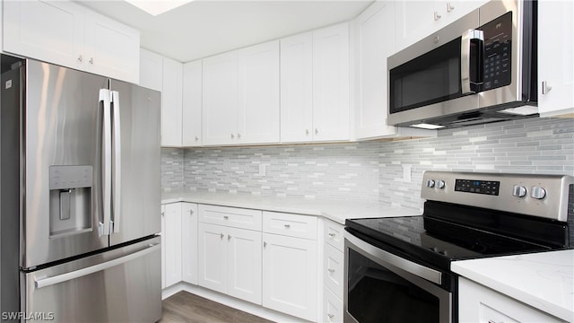 kitchen with appliances with stainless steel finishes, white cabinetry, decorative backsplash, and light stone counters