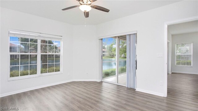 spare room with wood-type flooring, ceiling fan, and a healthy amount of sunlight