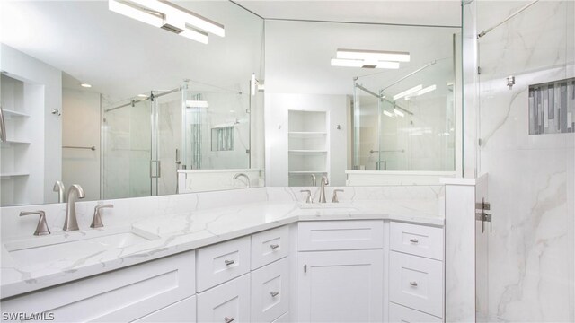 bathroom featuring dual vanity and walk in shower