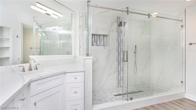 bathroom with vanity, a shower with door, and hardwood / wood-style floors