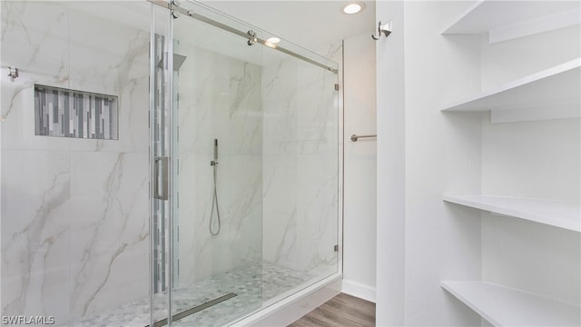 bathroom featuring a shower with door and hardwood / wood-style floors