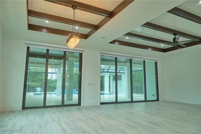 spare room featuring ceiling fan, baseboards, and beamed ceiling