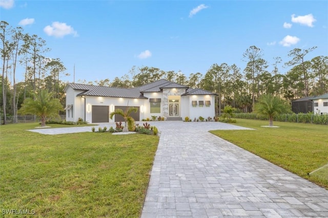 view of front of home with a garage and a front lawn