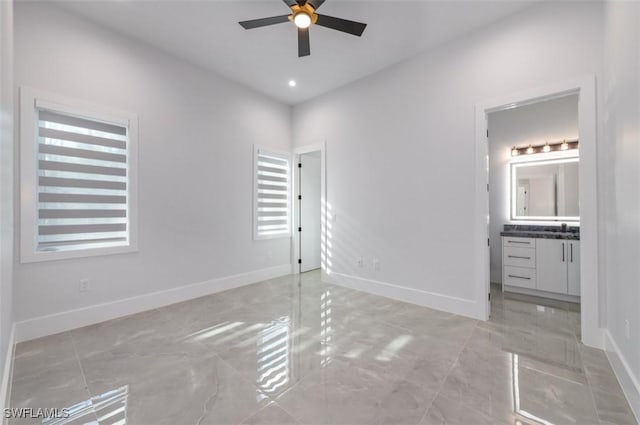 unfurnished bedroom featuring ensuite bathroom and ceiling fan