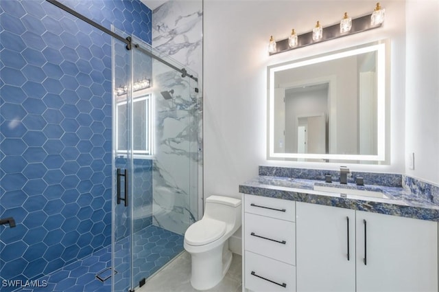 bathroom featuring vanity, a shower with shower door, and toilet