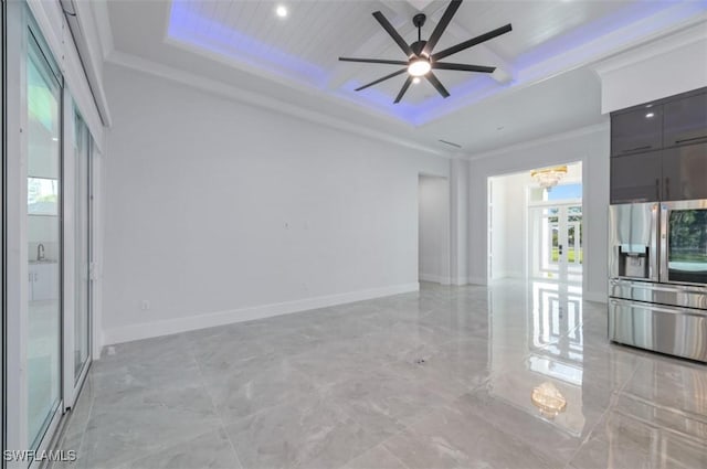 unfurnished living room featuring ceiling fan with notable chandelier, a raised ceiling, and ornamental molding