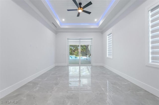 empty room with ceiling fan, ornamental molding, wood ceiling, and a tray ceiling