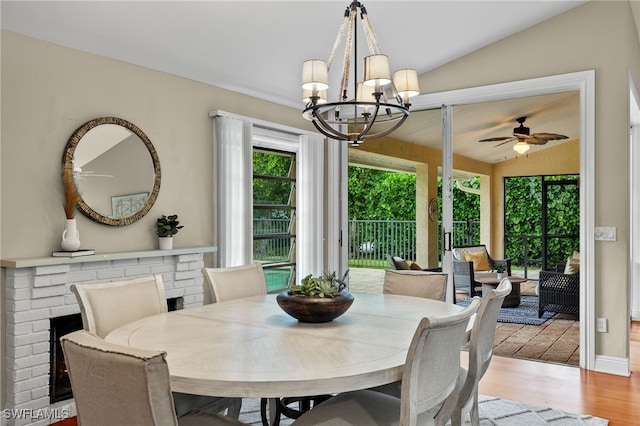 dining space featuring lofted ceiling, hardwood / wood-style floors, and ceiling fan with notable chandelier