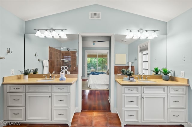 bathroom with lofted ceiling, vanity, tile patterned floors, and a shower