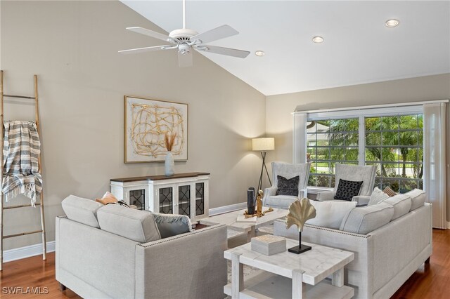 living room with dark hardwood / wood-style flooring, ceiling fan, and high vaulted ceiling