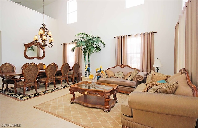 tiled living room featuring a towering ceiling, a notable chandelier, and a wealth of natural light